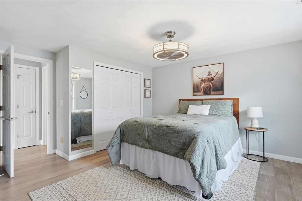 18 Carriage Court, Unit 18 Merrimac, MA 01860 - Photo 24 of 38 a bedroom with a bed and a chandelier