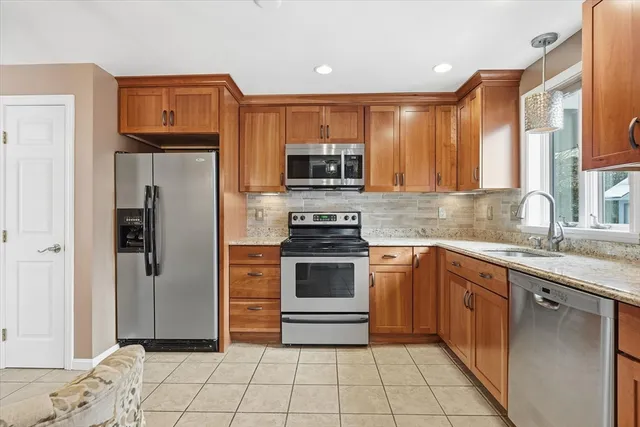 a kitchen with stainless steel appliances granite countertop a refrigerator and a stove
