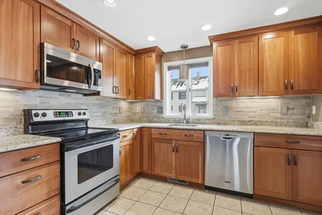 a kitchen with granite countertop cabinets stainless steel appliances and a sink