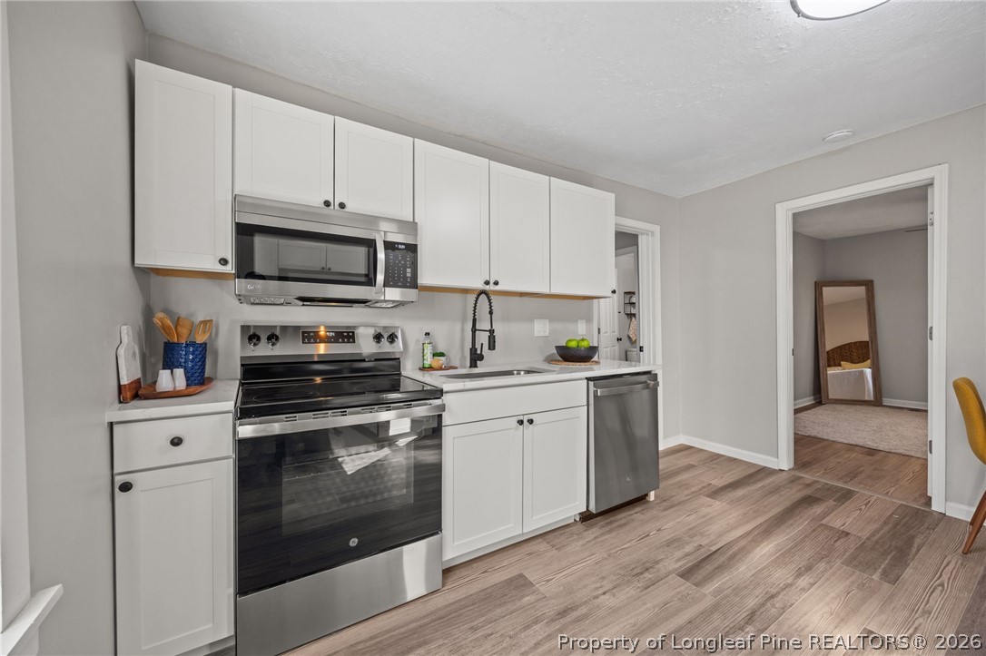 625 Eva Circle Spring Lake, NC 28390 - Photo 15 of 28 a kitchen with stainless steel appliances granite countertop a stove a sink and a refrigerator