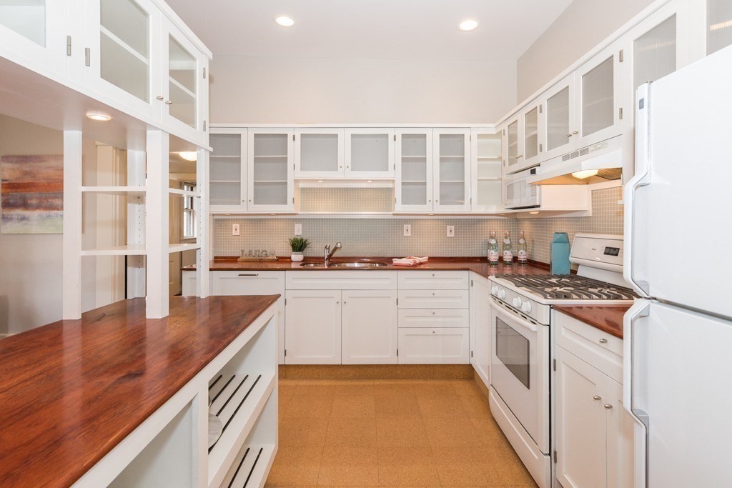 12 Willow Court, Unit A Arlington, MA 02476 - Photo 2 of 16 a kitchen with stainless steel appliances granite countertop a stove and a white cabinets