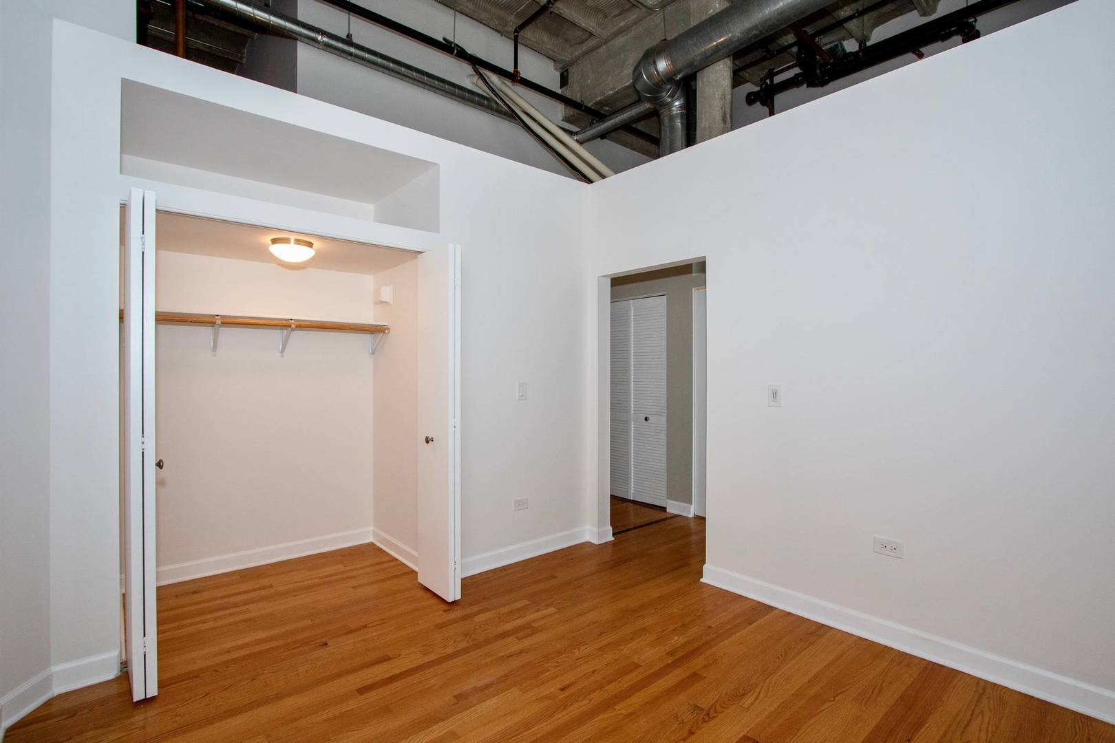 2545 South Dearborn Street, Unit 608 Chicago, IL 60616 - Photo 14 of 28 a view of an empty room with wooden floor