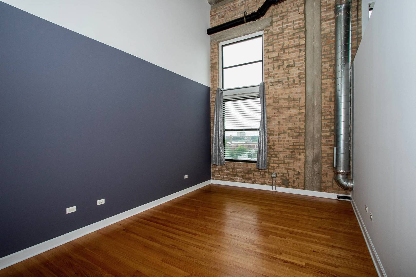 2545 South Dearborn Street, Unit 608 Chicago, IL 60616 - Photo 5 of 28 a view of an empty room with wooden floor and a window