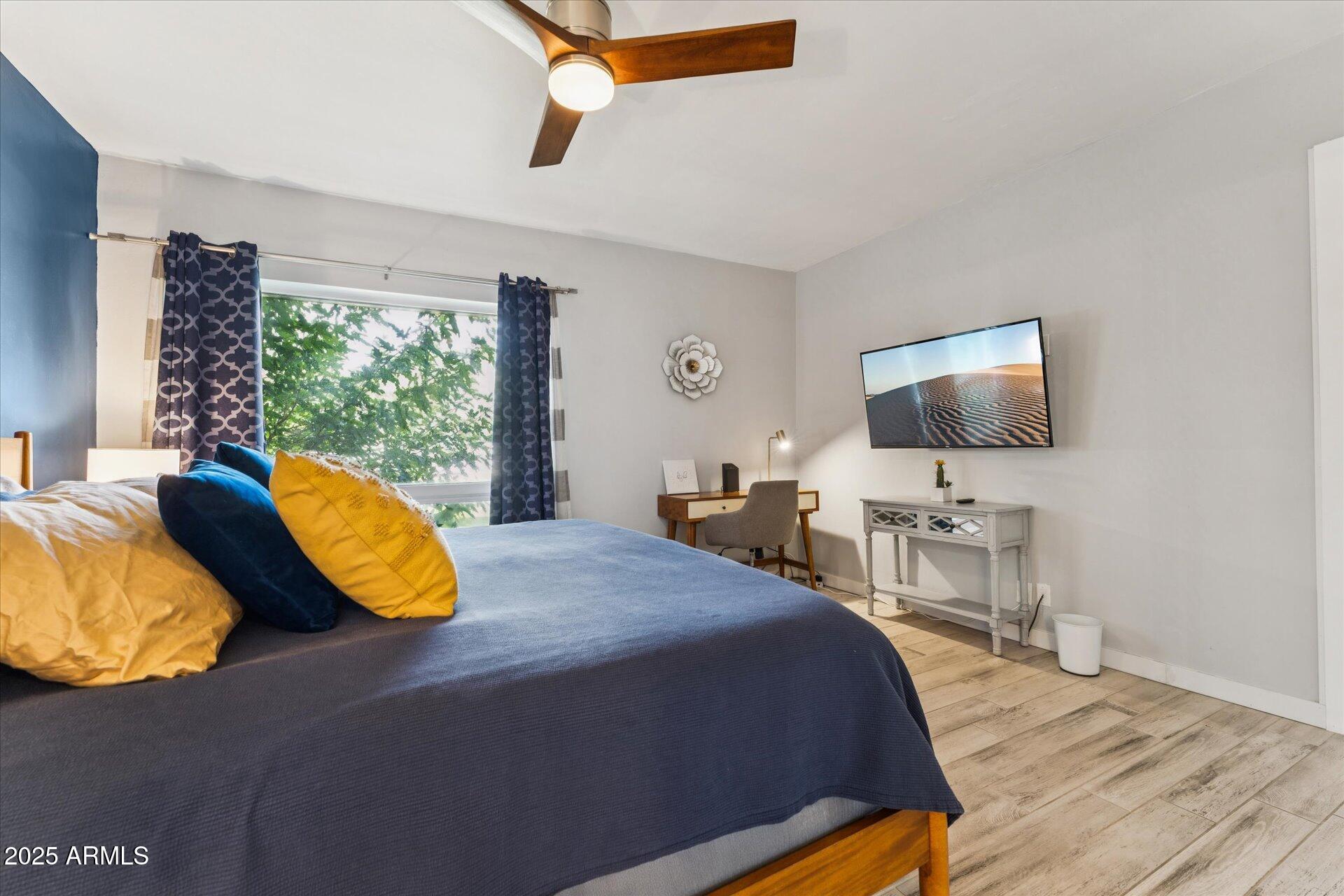 3242 East Camelback Road, Unit 105 Phoenix, AZ 85018 - Photo 14 of 24 a bedroom with a bed and flat tv screen on the dresser