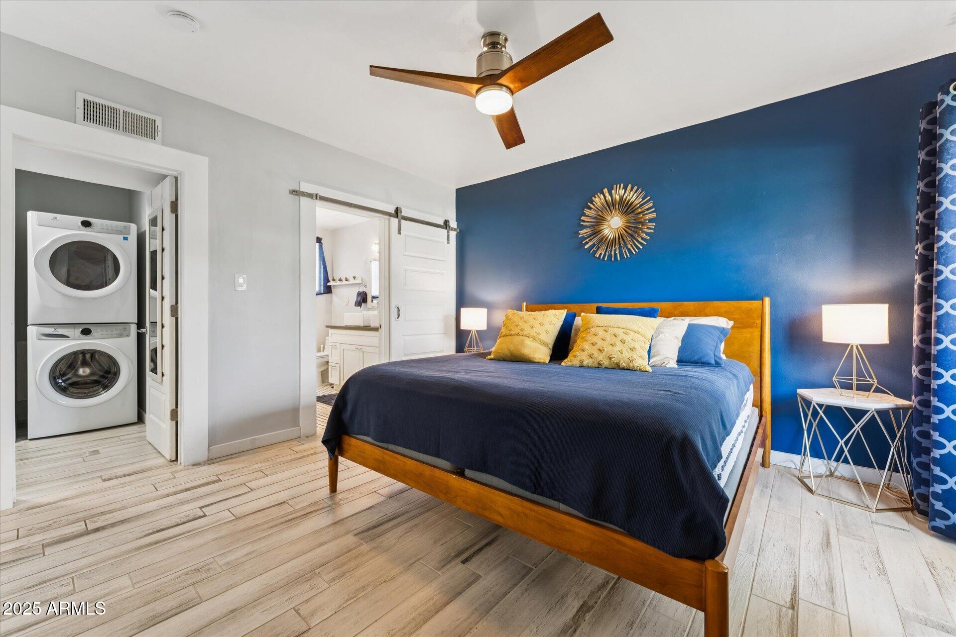 3242 East Camelback Road, Unit 105 Phoenix, AZ 85018 - Photo 15 of 24 a bedroom with a bed and dresser with wooden floor