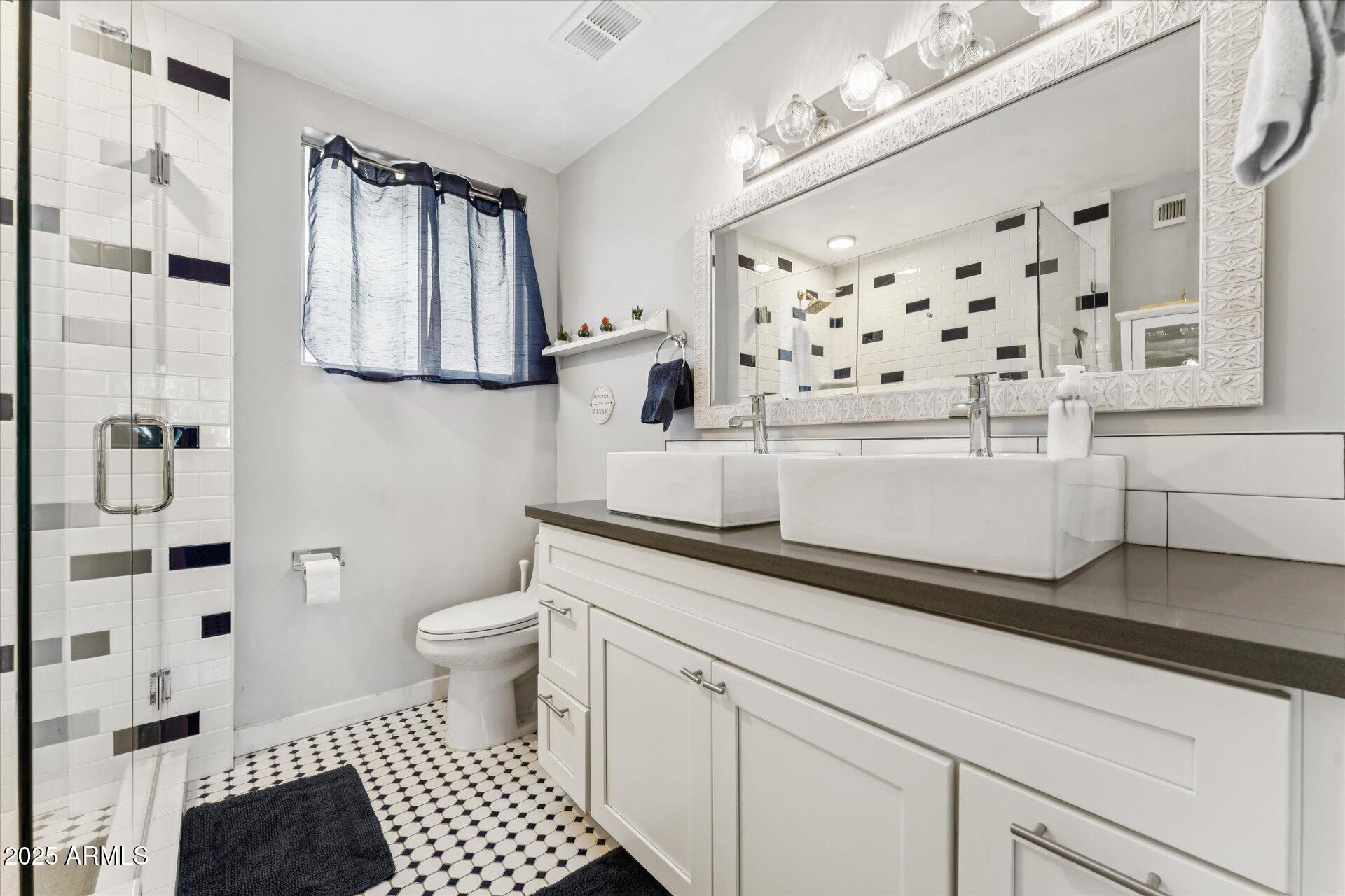 3242 East Camelback Road, Unit 105 Phoenix, AZ 85018 - Photo 17 of 24 a bathroom with a sink a toilet and shower curtain