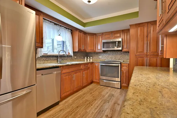 a kitchen with granite countertop a stove cabinets and a sink