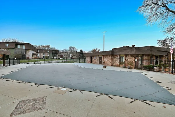 a view of a house with a yard and a bench