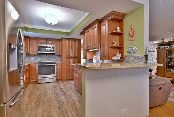 a kitchen with stainless steel appliances granite countertop a stove refrigerator and microwave