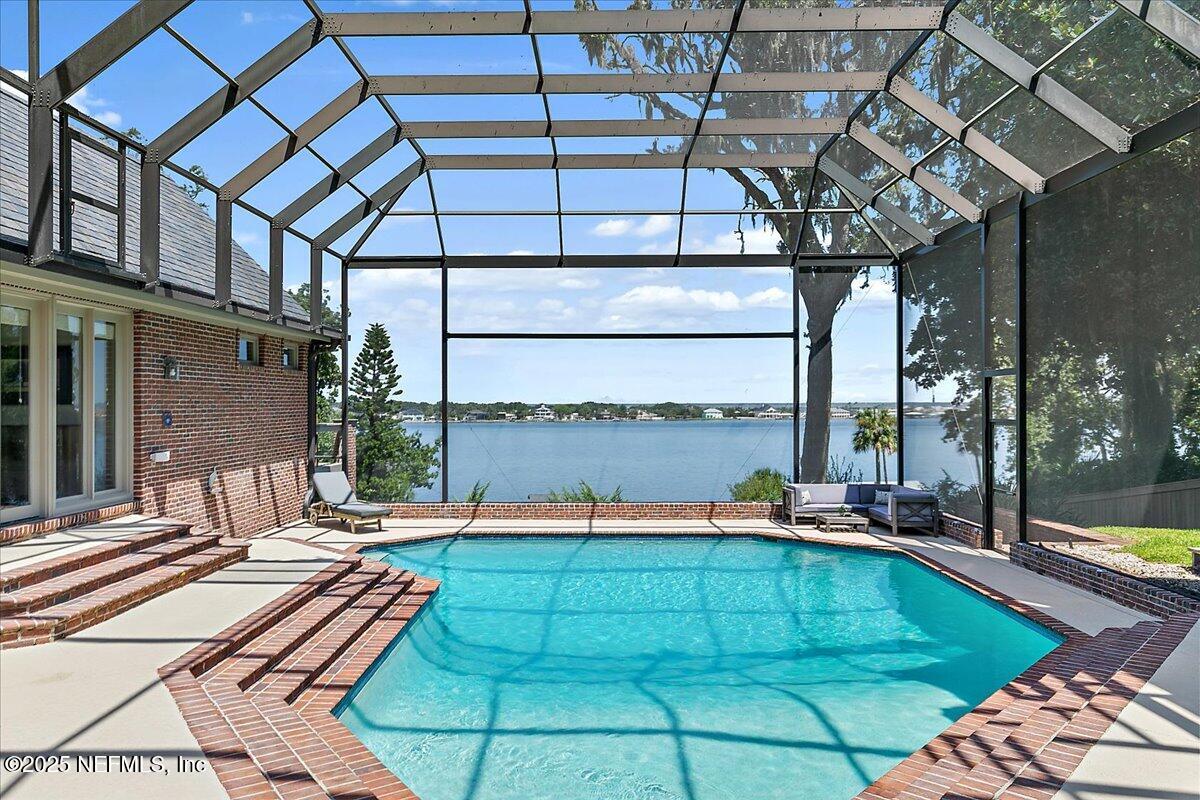 12827 Fort Caroline Road Jacksonville, FL 32225 - Photo 22 of 42 a view of a swimming pool with a lounge chairs in front of house