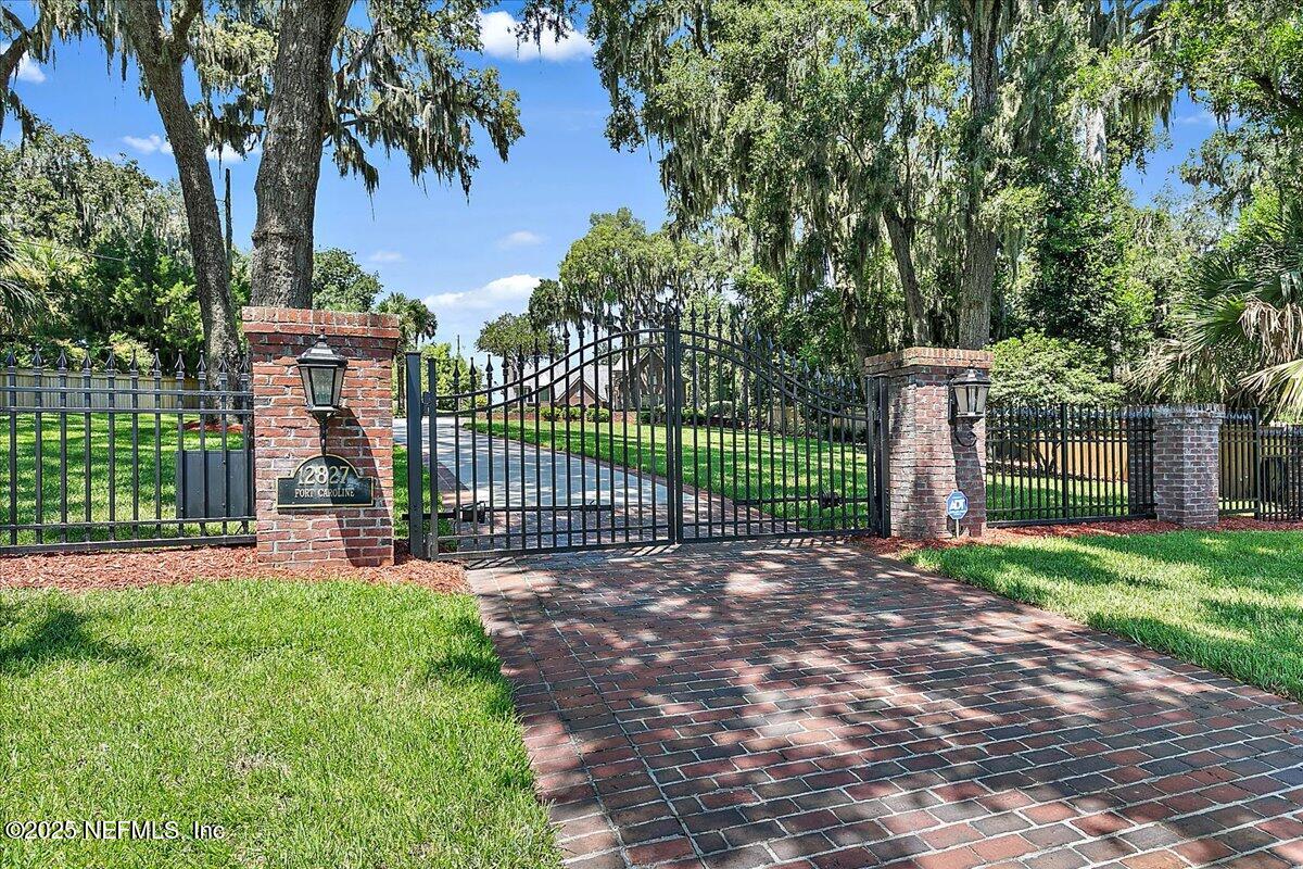 12827 Fort Caroline Road Jacksonville, FL 32225 - Photo 9 of 42 a view of a house with a small yard and a large tree