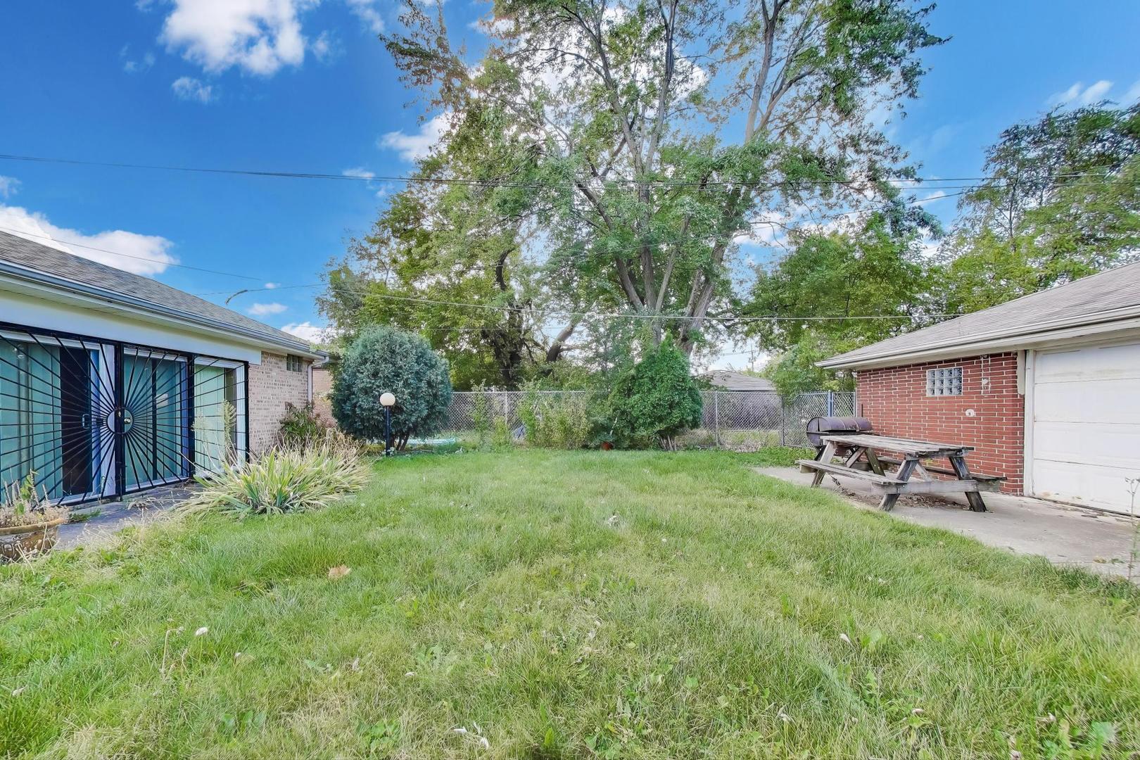 8622 South Michigan Avenue Chicago, IL 60619 - Photo 19 of 20 a view of a backyard with table and chairs and a large tree