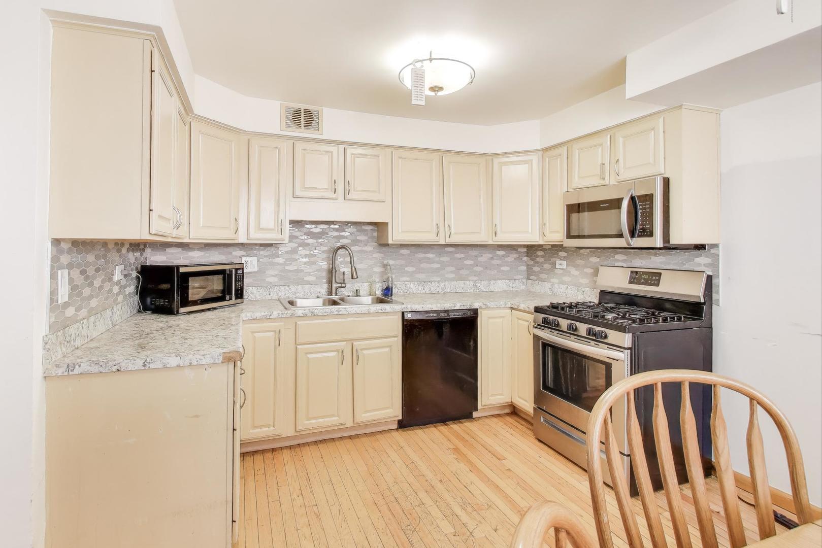 8622 South Michigan Avenue Chicago, IL 60619 - Photo 5 of 20 a kitchen with stainless steel appliances granite countertop a stove a sink and a microwave
