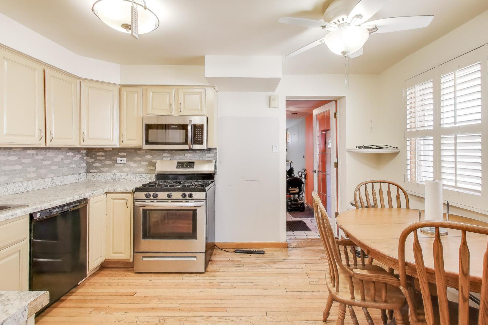 8622 South Michigan Avenue Chicago, IL 60619 - Photo 6 of 20 a kitchen with stainless steel appliances granite countertop a stove top oven a sink a dining table and chairs