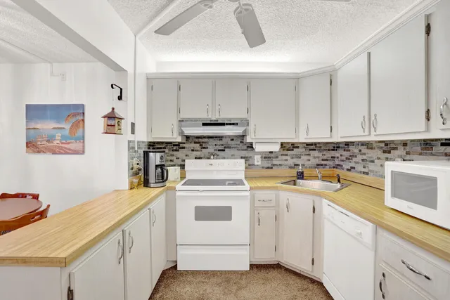 a kitchen with cabinets appliances a sink and a counter top space
