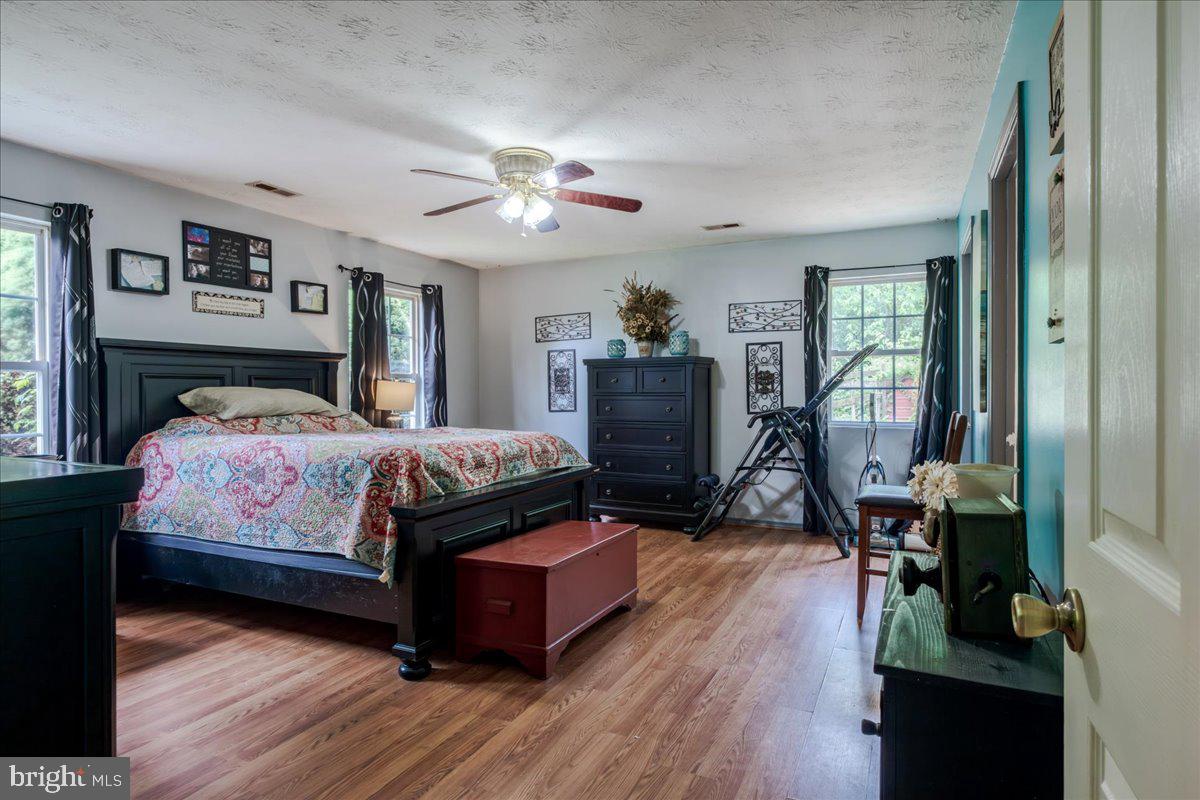 11419 Oak Grove Road Bristol, VA 24202 - Photo 20 of 36 a bedroom with a bed wooden floor and a chandelier