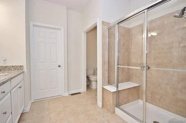 a bathroom with a granite countertop double vanity sink and mirror