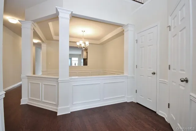 a view of a livingroom with a chandelier fan and windows