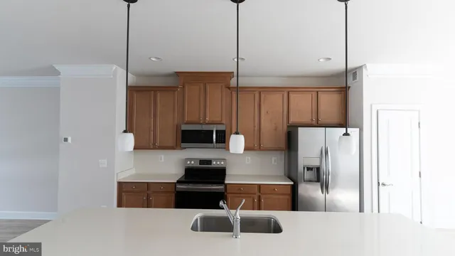 a kitchen with stainless steel appliances a refrigerator a stove a sink and a center island