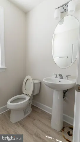 a bathroom with a sink toilet and a mirror
