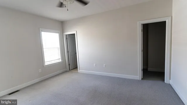 an empty room with windows and closet