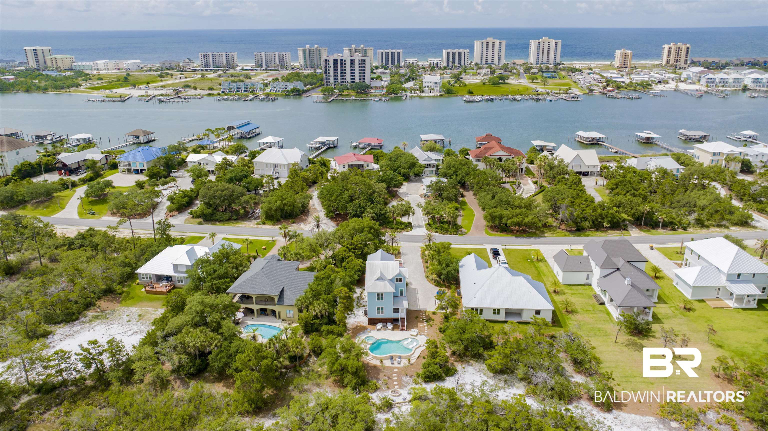 30351 River Road Orange Beach, AL 36561 - Photo 4 of 44 Aerial perspective showcasing multiple properties, a prominent waterway, and a distant coastline with structures