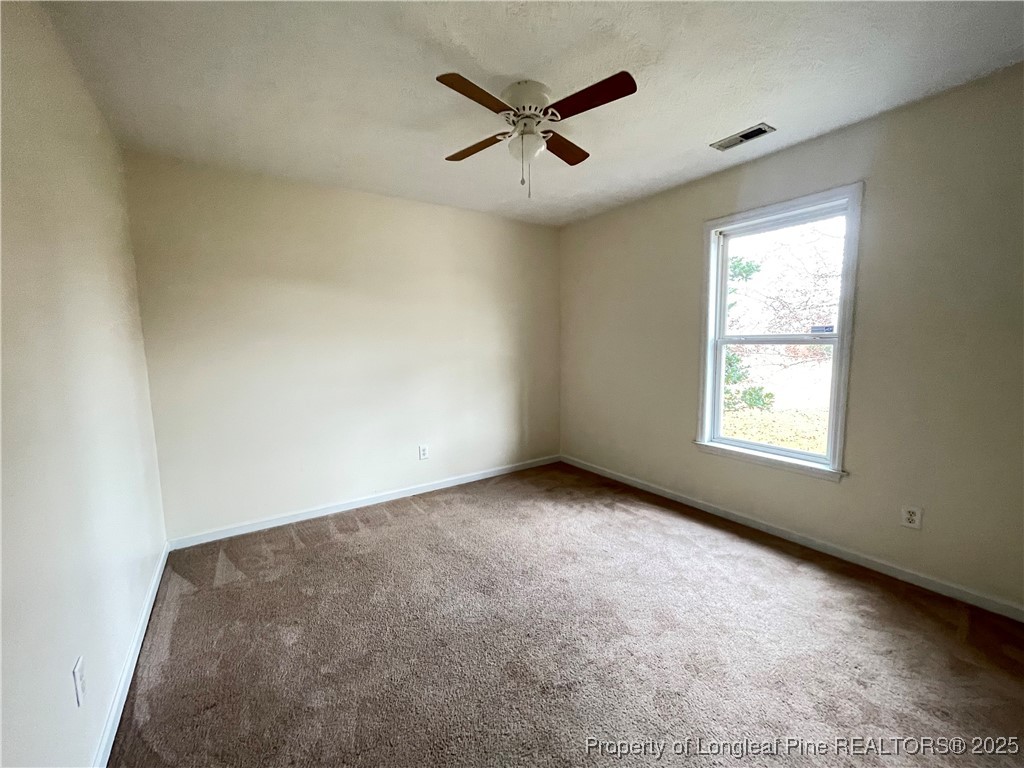 177 Deep Creek Lane Raeford, NC 28376 - Photo 14 of 28 an empty room with ceiling fan and windows