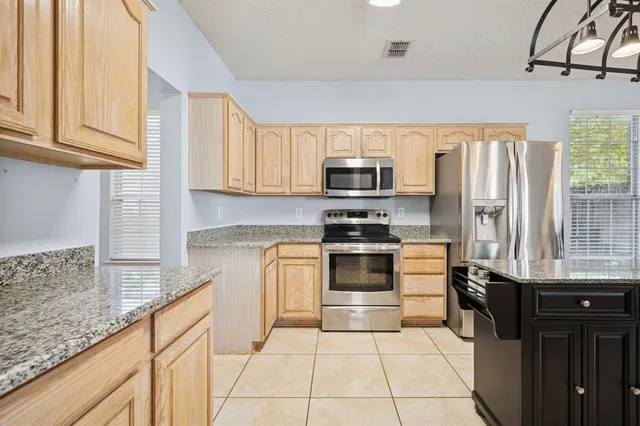 a kitchen with stainless steel appliances a sink cabinets and a window