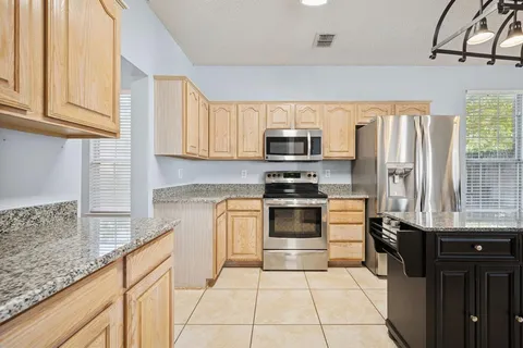 a kitchen with stainless steel appliances a sink cabinets and a window