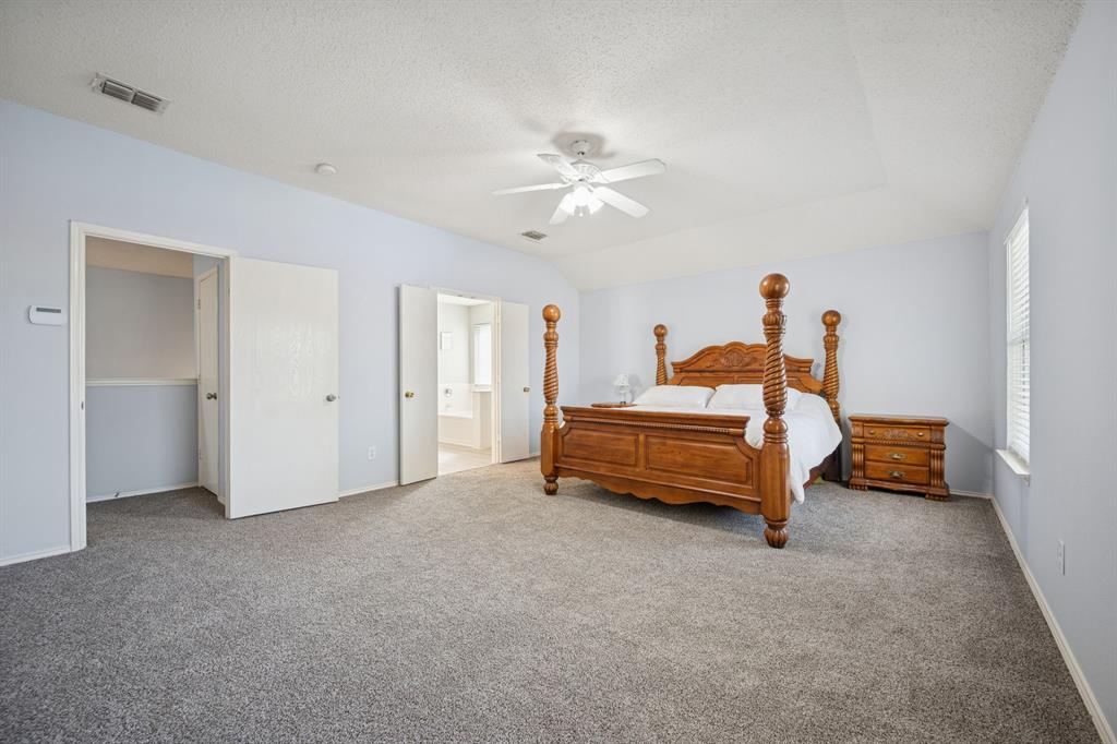 3304 Olympus Court Corinth, TX 76210 - Photo 7 of 40 a bedroom with a bed and a chandelier