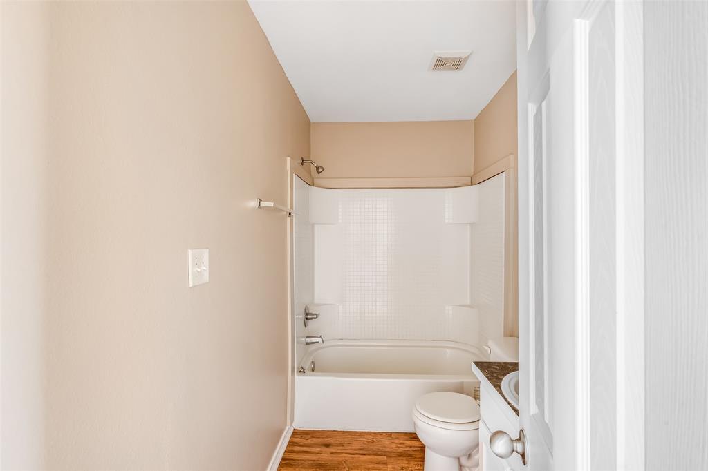 892 West Vanderbilt Street Stephenville, TX 76401 - Photo 29 of 34 a bathroom with a granite countertop shower and a toilet
