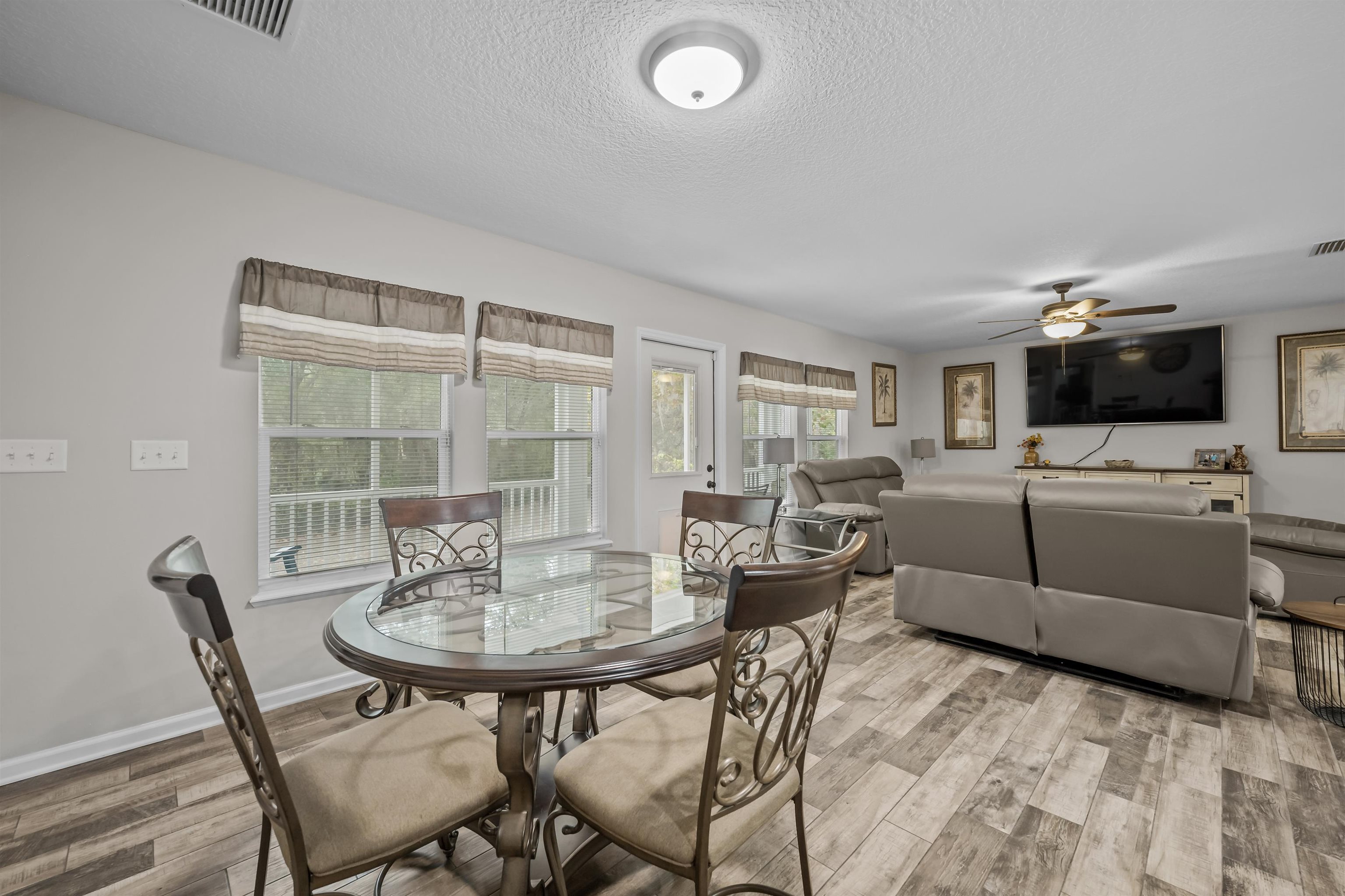 232 Kyte Road San Mateo, FL 32187 - Photo 15 of 36 Dining space with wood finished floors, a textured ceiling, and a ceiling fan