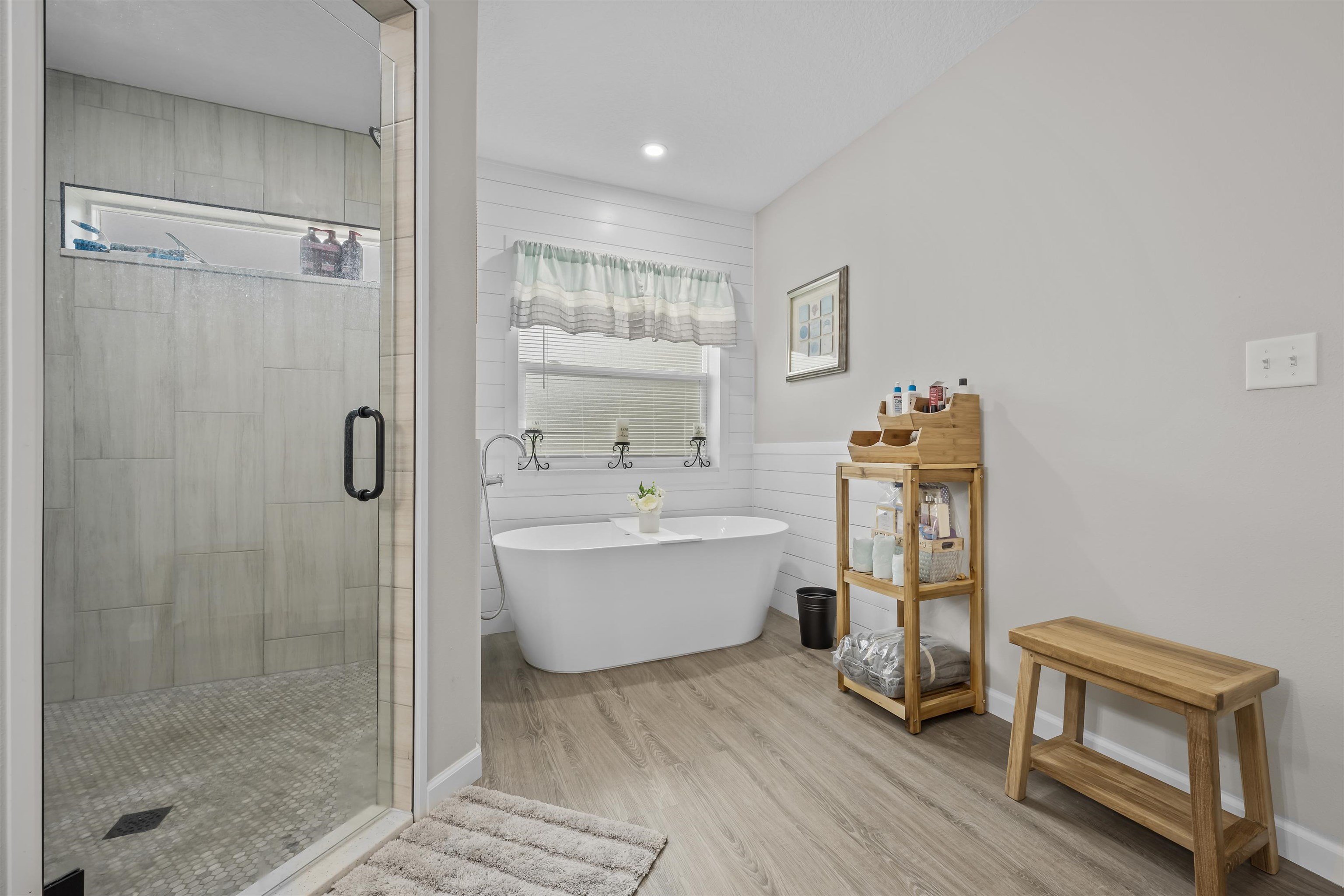 232 Kyte Road San Mateo, FL 32187 - Photo 21 of 36 Full bath featuring a freestanding tub, a wainscoted wall, a stall shower, and wood finished floors