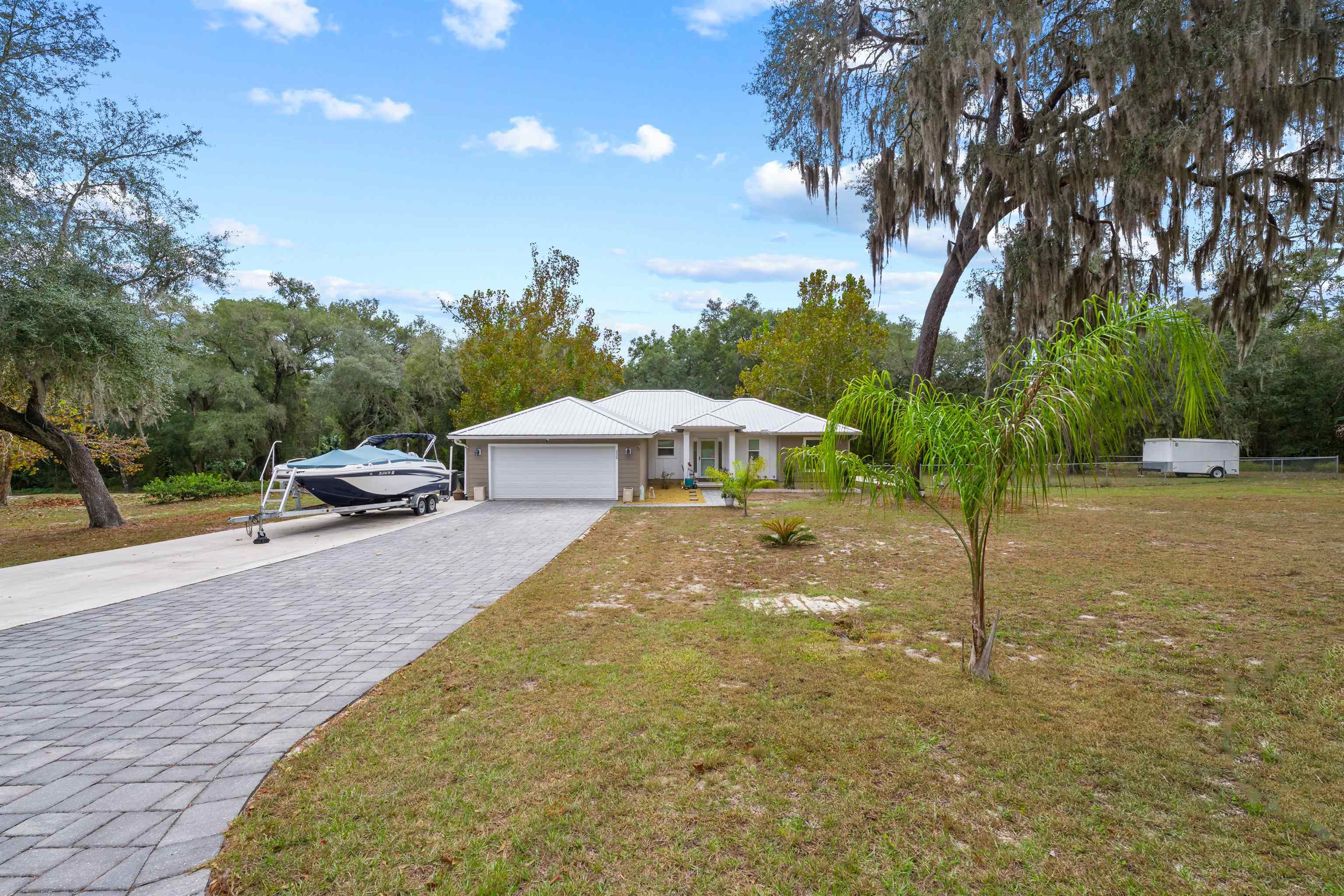 232 Kyte Road San Mateo, FL 32187 - Photo 32 of 36 Ranch-style house with decorative driveway, a front yard, and an attached garage