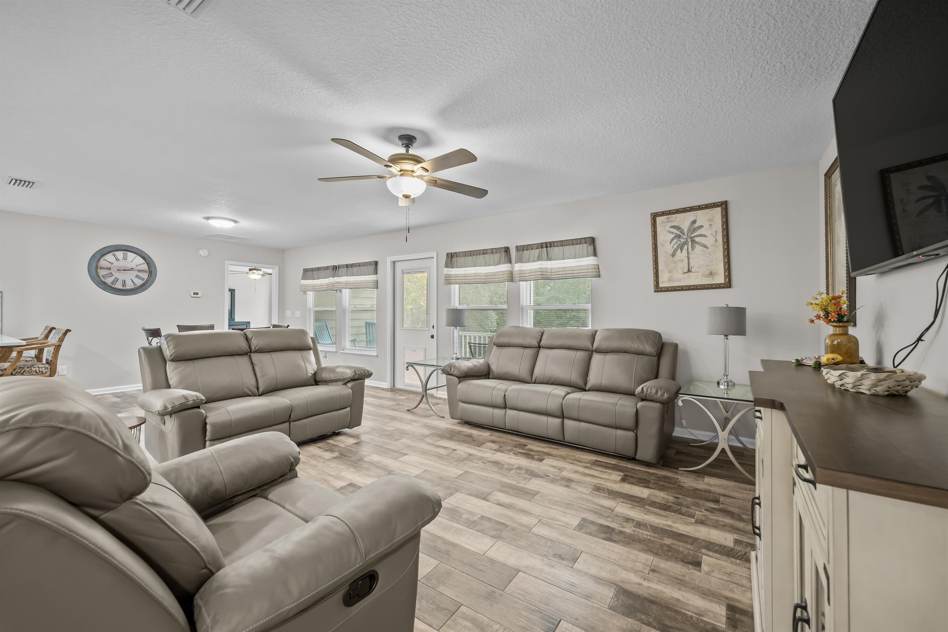 232 Kyte Road San Mateo, FL 32187 - Photo 7 of 36 Living room featuring ceiling fan, light wood-style floors, and a textured ceiling