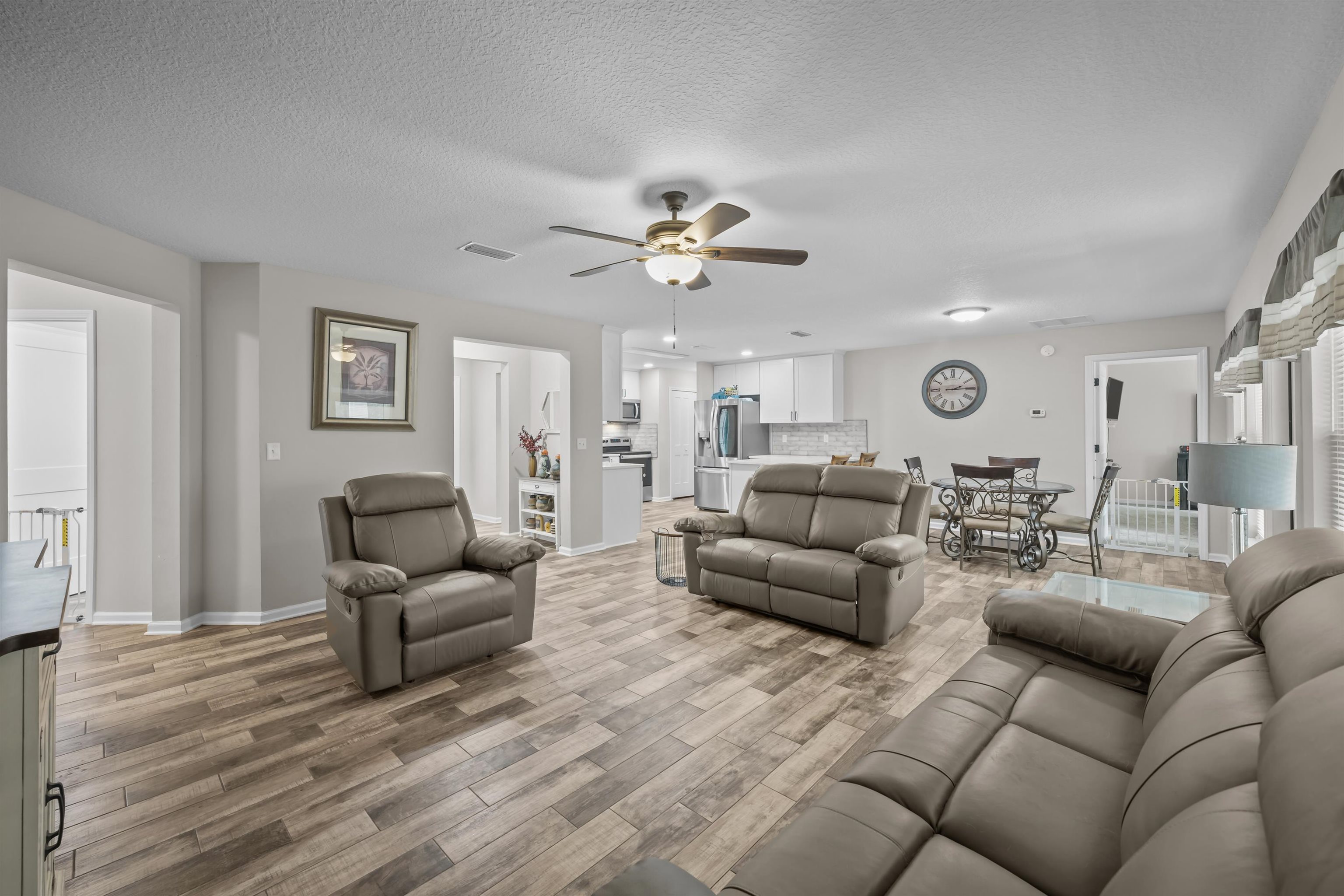 232 Kyte Road San Mateo, FL 32187 - Photo 8 of 36 Living area with a textured ceiling, light wood-style flooring, and a ceiling fan