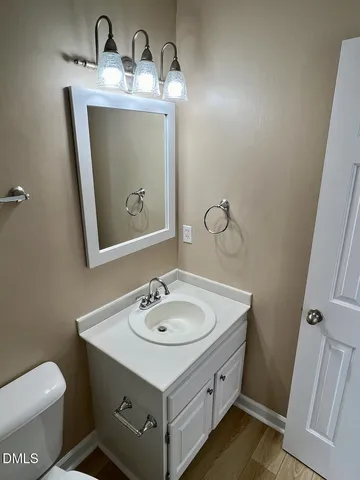 a bathroom with a sink toilet and mirror
