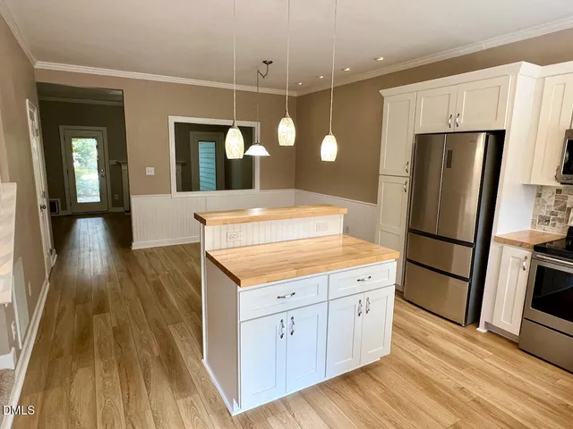 a kitchen with a refrigerator a sink and dishwasher with wooden floor
