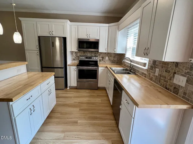 a kitchen with stainless steel appliances granite countertop a stove a sink and a refrigerator