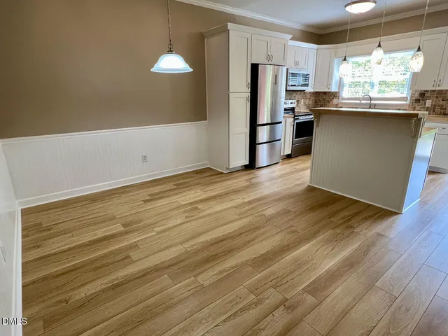a kitchen with stainless steel appliances granite countertop a refrigerator and a stove top oven