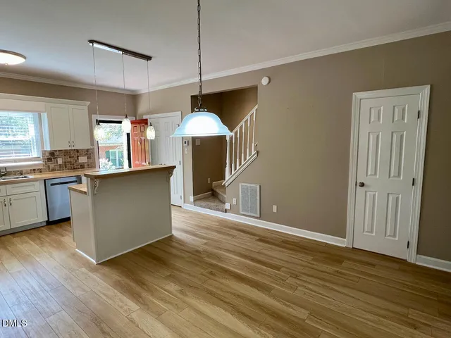 a kitchen with stainless steel appliances granite countertop a sink a stove and a wooden floors
