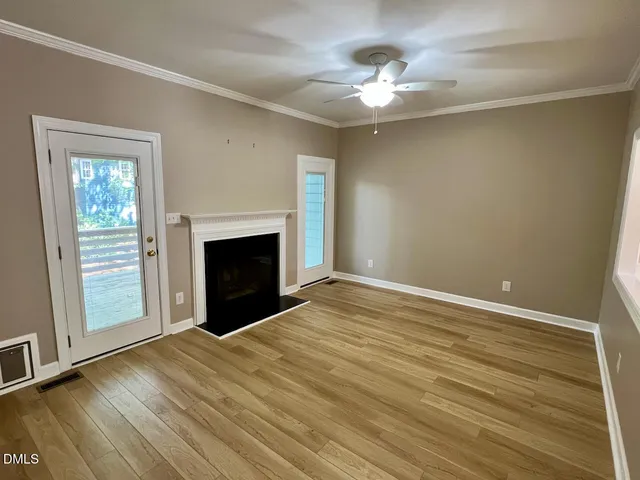 wooden floor fireplace and windows in an empty room