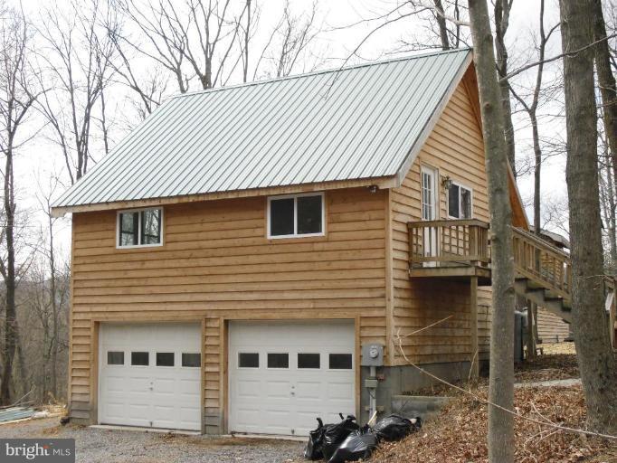 21 Riggs Lane Capon Bridge, WV 26711 - Photo 2 of 24 a front view of a house with garage