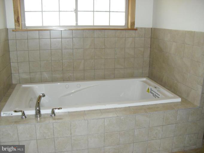 21 Riggs Lane Capon Bridge, WV 26711 - Photo 12 of 24 a bath tub sitting in a bathroom next to a window