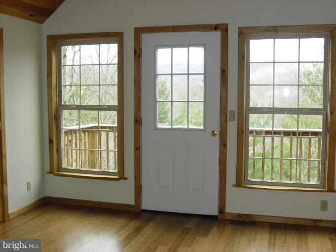 21 Riggs Lane Capon Bridge, WV 26711 - Photo 3 of 24 a view of an empty room with wooden floor and a window