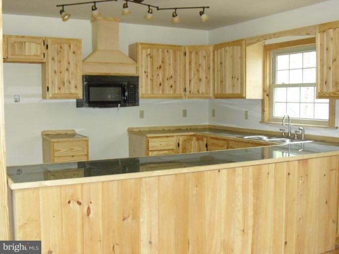 21 Riggs Lane Capon Bridge, WV 26711 - Photo 7 of 24 a kitchen with stainless steel appliances a sink a stove and white cabinets