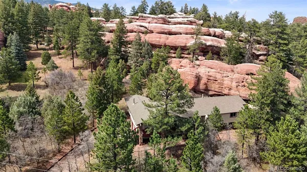 an aerial view of residential house with outdoor space and trees all around