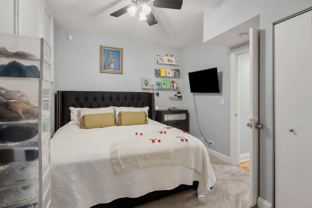 a bedroom with a bed a flat screen tv and a chandelier