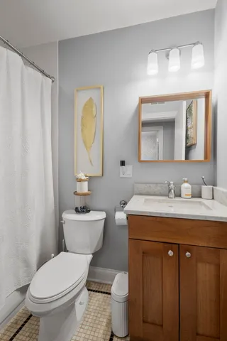 a bathroom with a toilet sink vanity and mirror