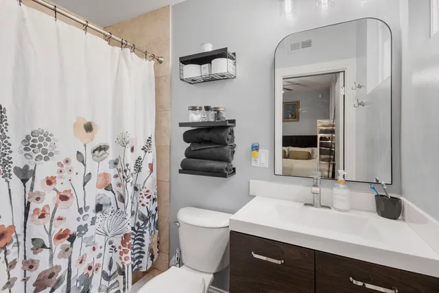 a bathroom with a sink a toilet and shower curtain